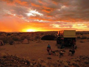 Safari truck camping in the sunset in the Namibian desert